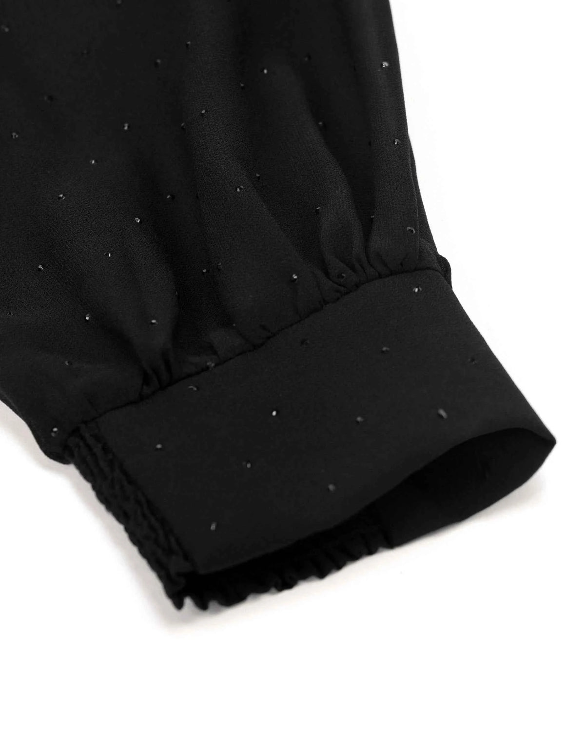 The transparent sleeve gathers above a plain cuff, with tiny reflective points visible across the fabric.