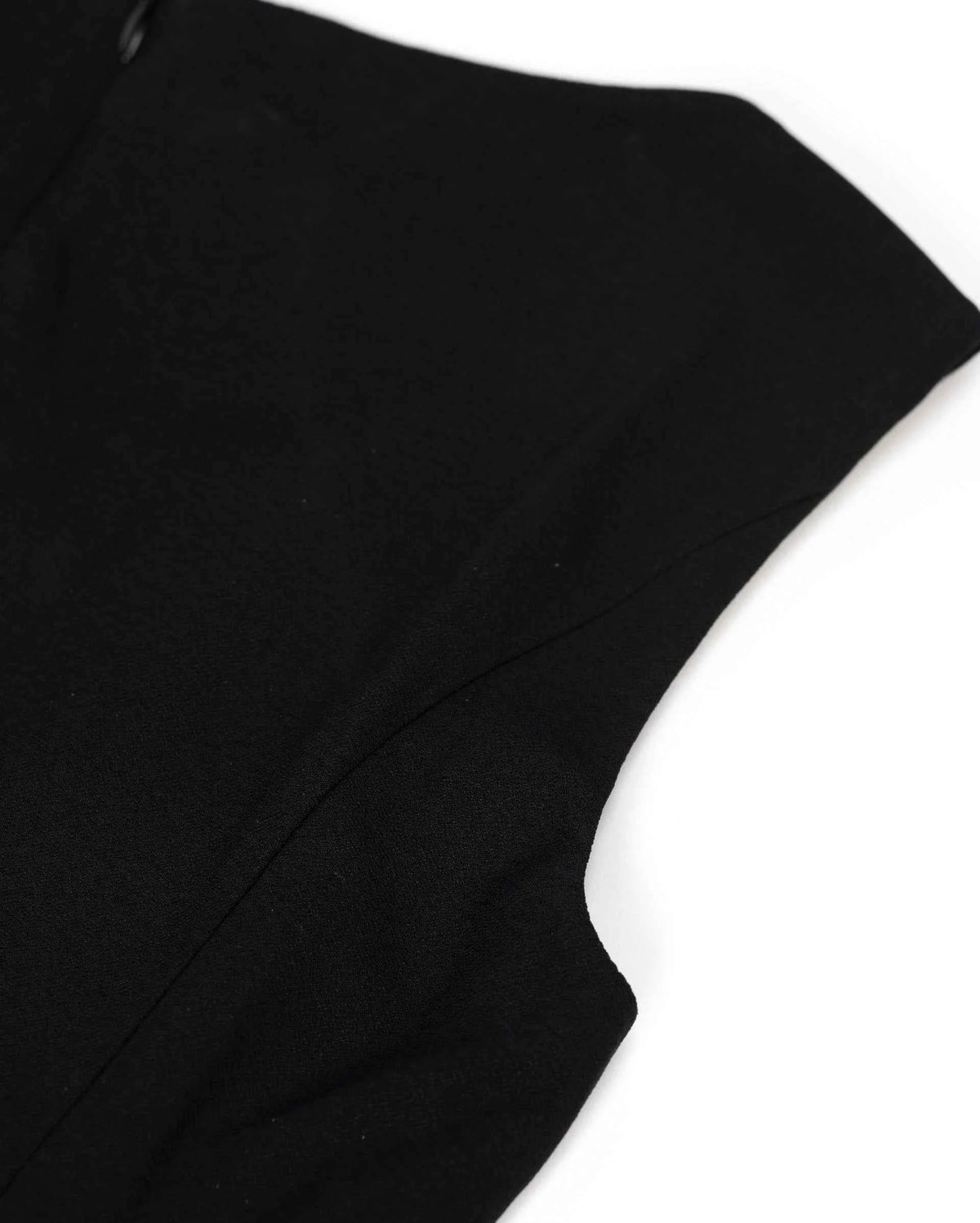 The shoulder and arm opening keep a plain, softly curved shape against the black body.