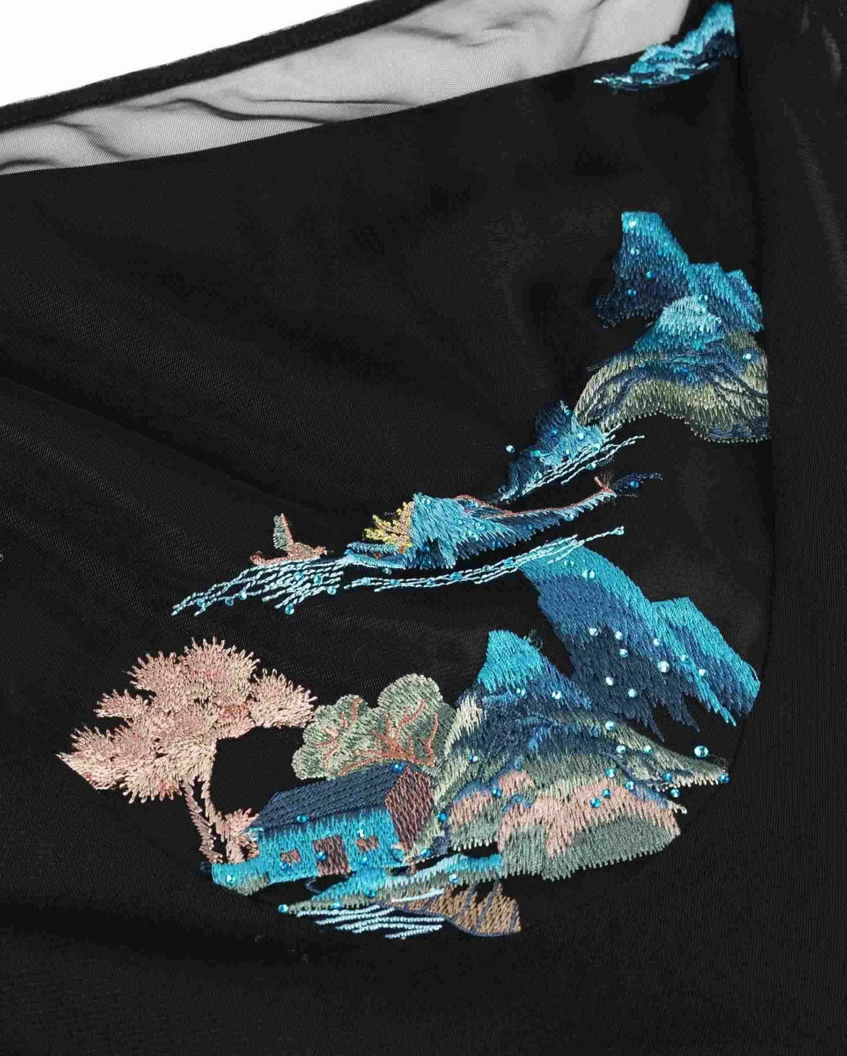 Blue mountains, pale blossoms and architectural forms come together on the black ground.