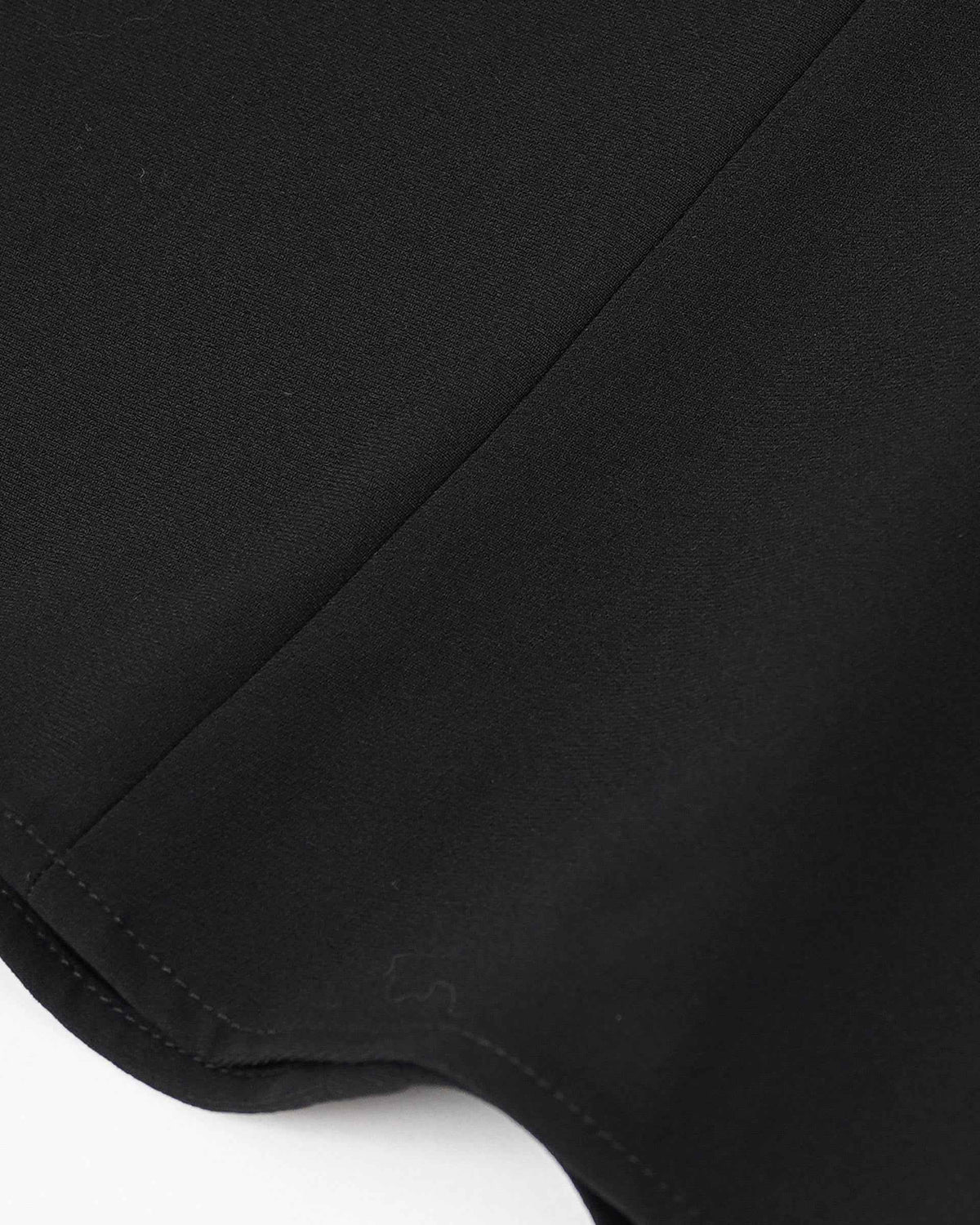 The close-up follows the skirt's curved lower edge and its tonal stitching.