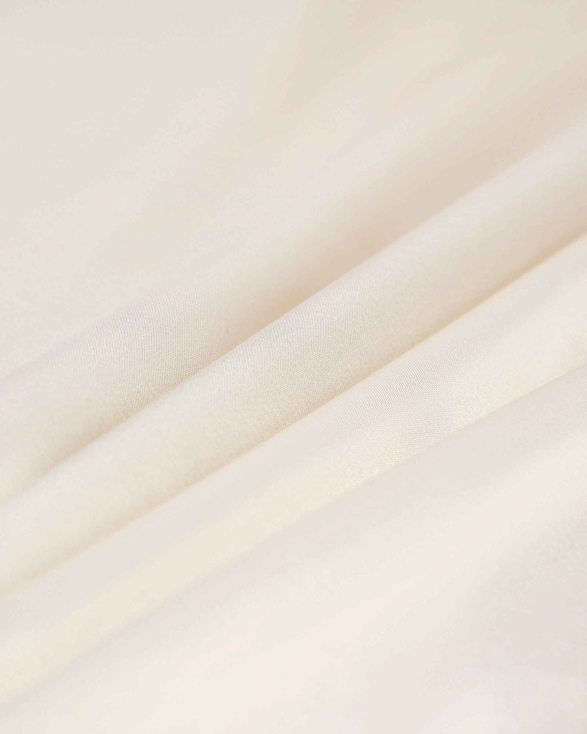 The pale fabric forms broad, soft folds with subtle changes in light.