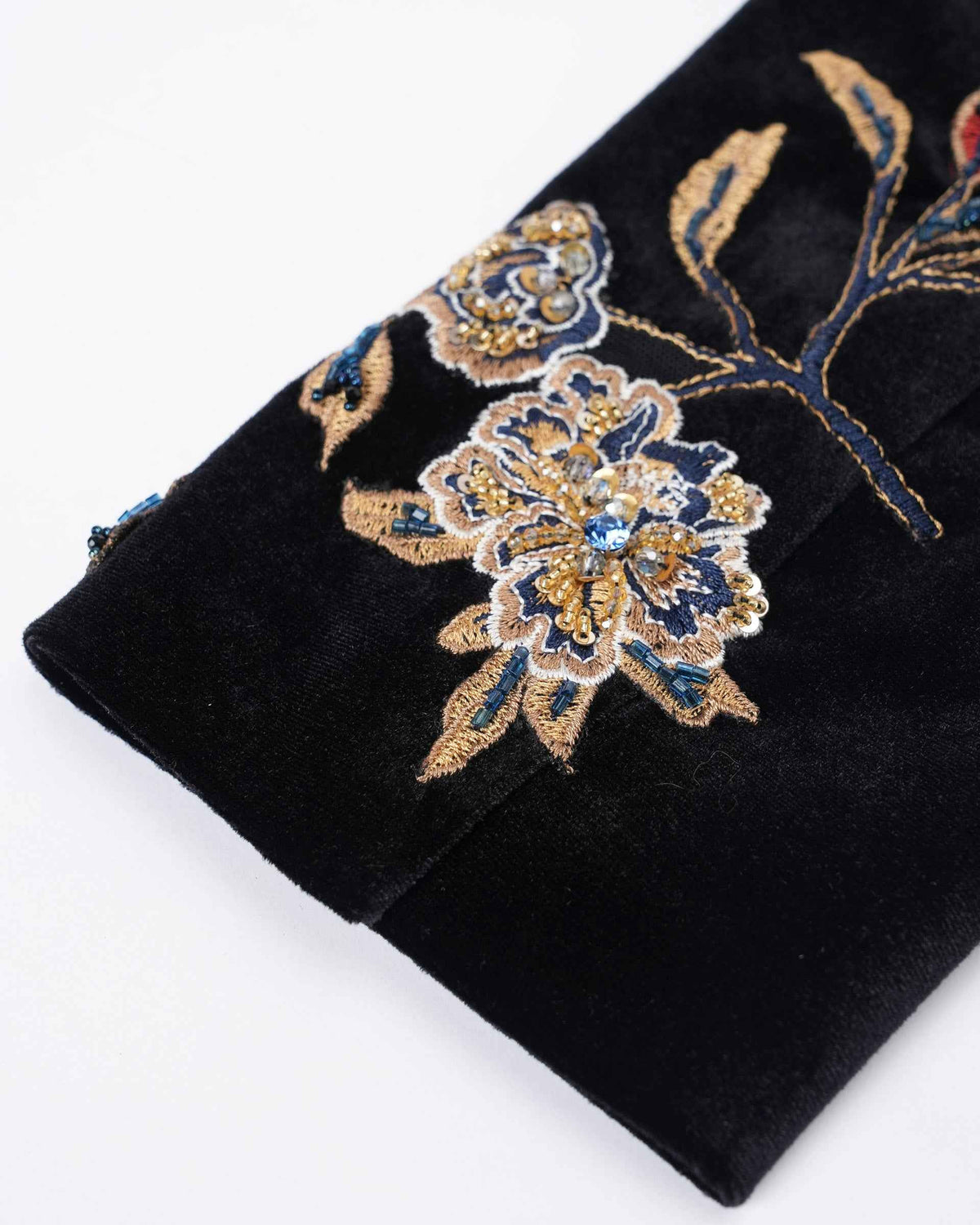 A single embroidered flower stands out on the dark cuff, with small leaves extending along the sleeve.