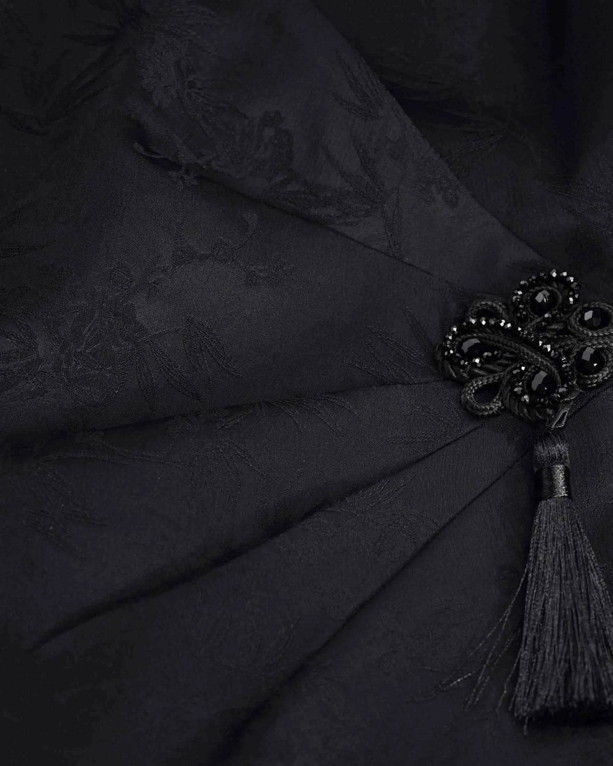 A dark decorative knot sits where the front fabric gathers at the waist.