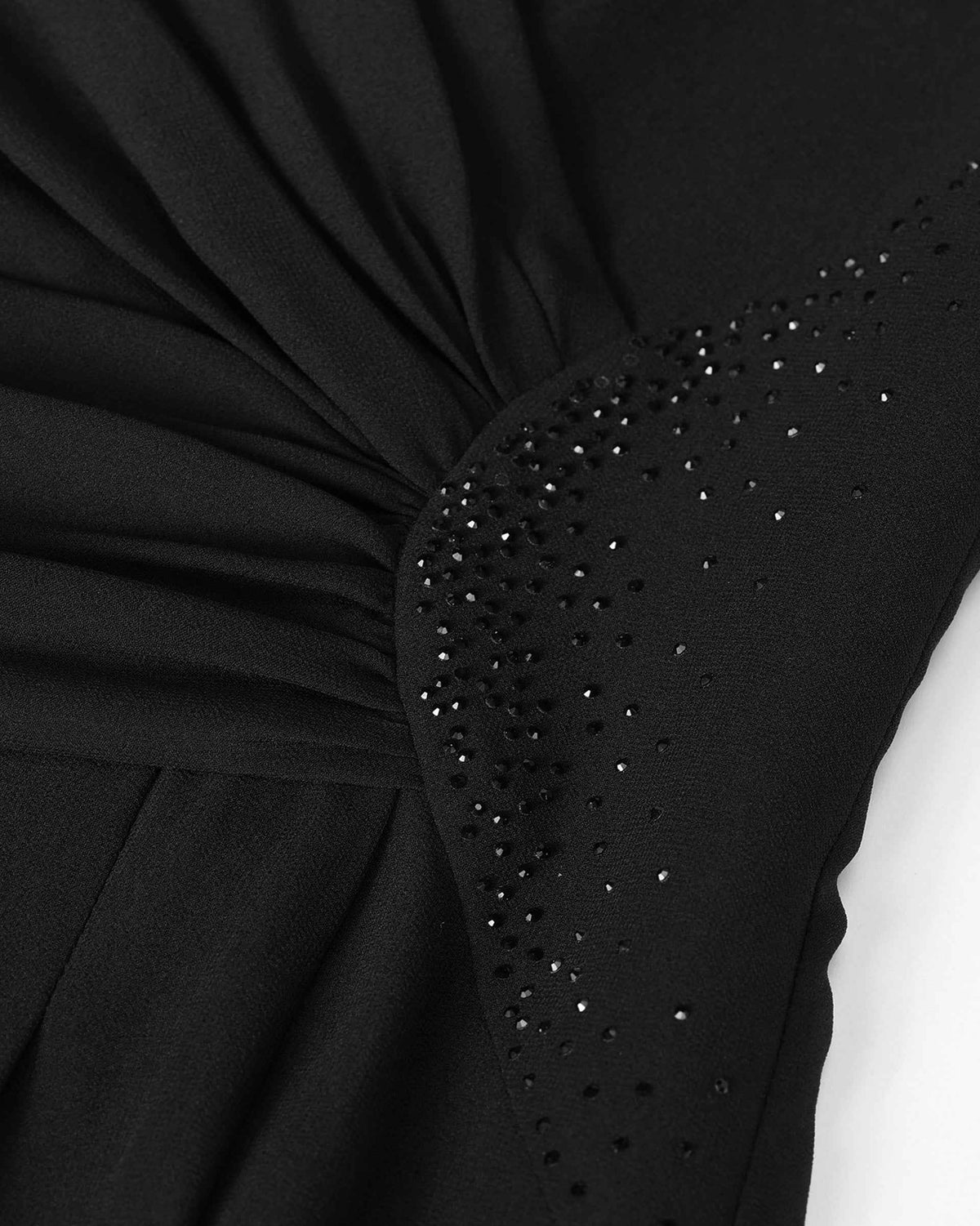 Fine folds gather beside a curved area of small dark embellishments at the waist.