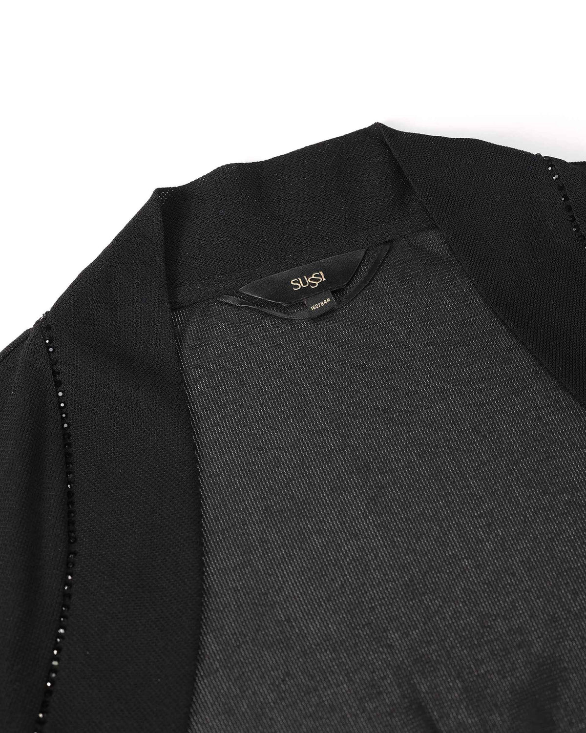Transparent fabric meets the darker sleeve near the shoulder, creating a subtle contrast in coverage.