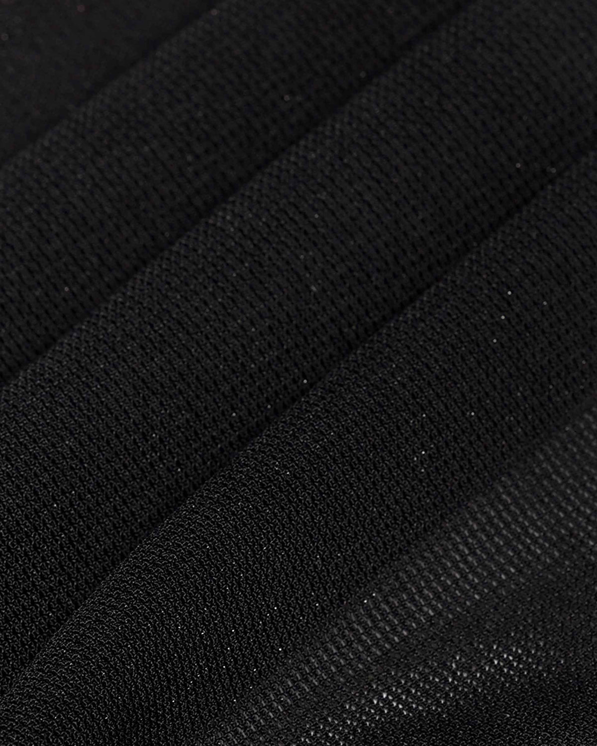 The close view reveals a fine, open fabric structure against the dark ground.