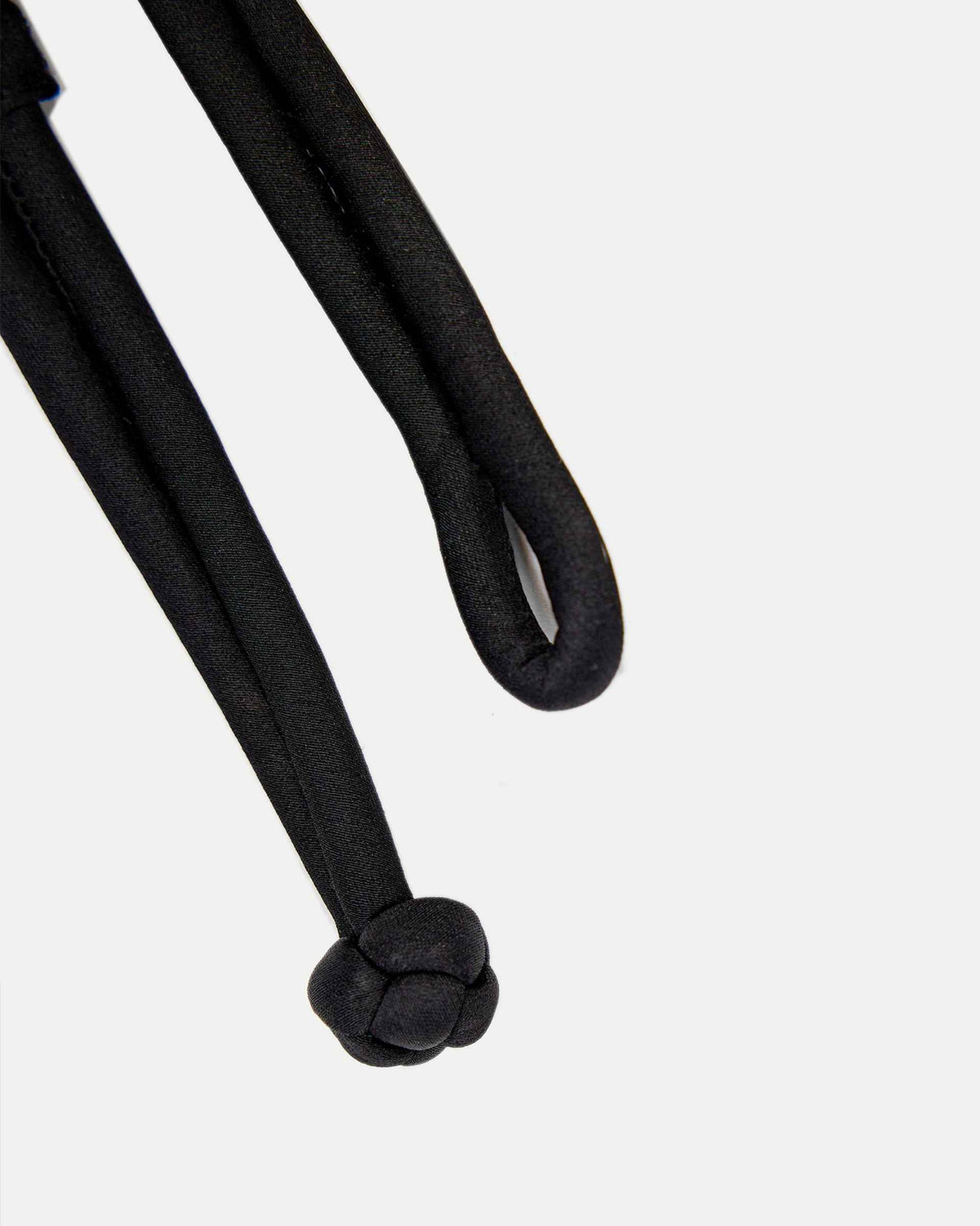 The narrow belt ends in a rounded, flower-like button beside a slim loop.