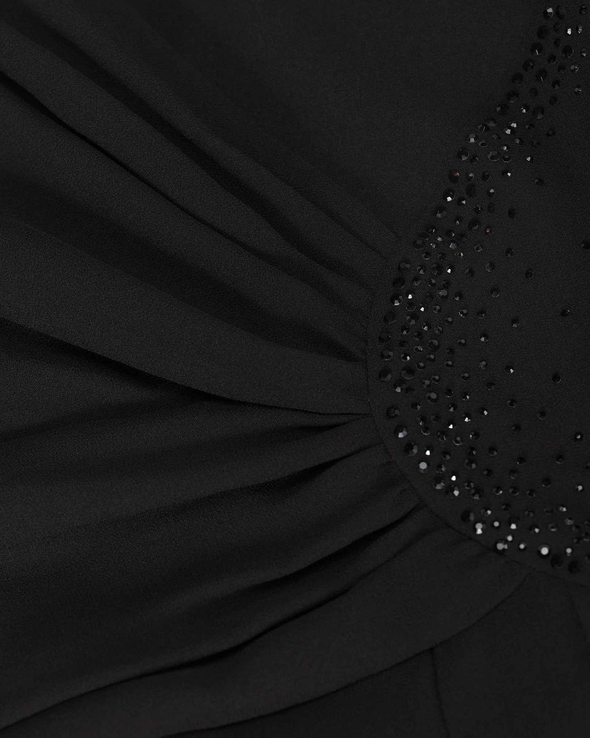 The fabric gathers towards a curved decorated area at the waist, with small reflective points following its edge.