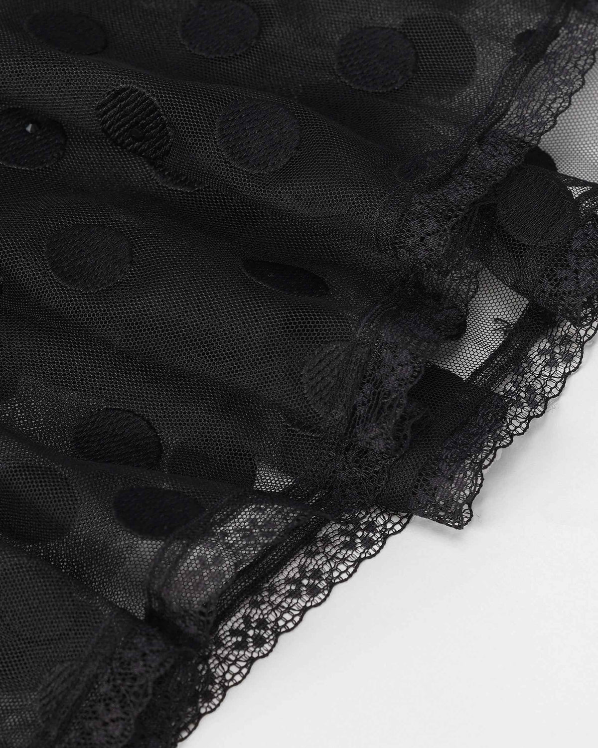 Lace completes the lower edge beneath the transparent outer layer, adding a fine decorative finish.