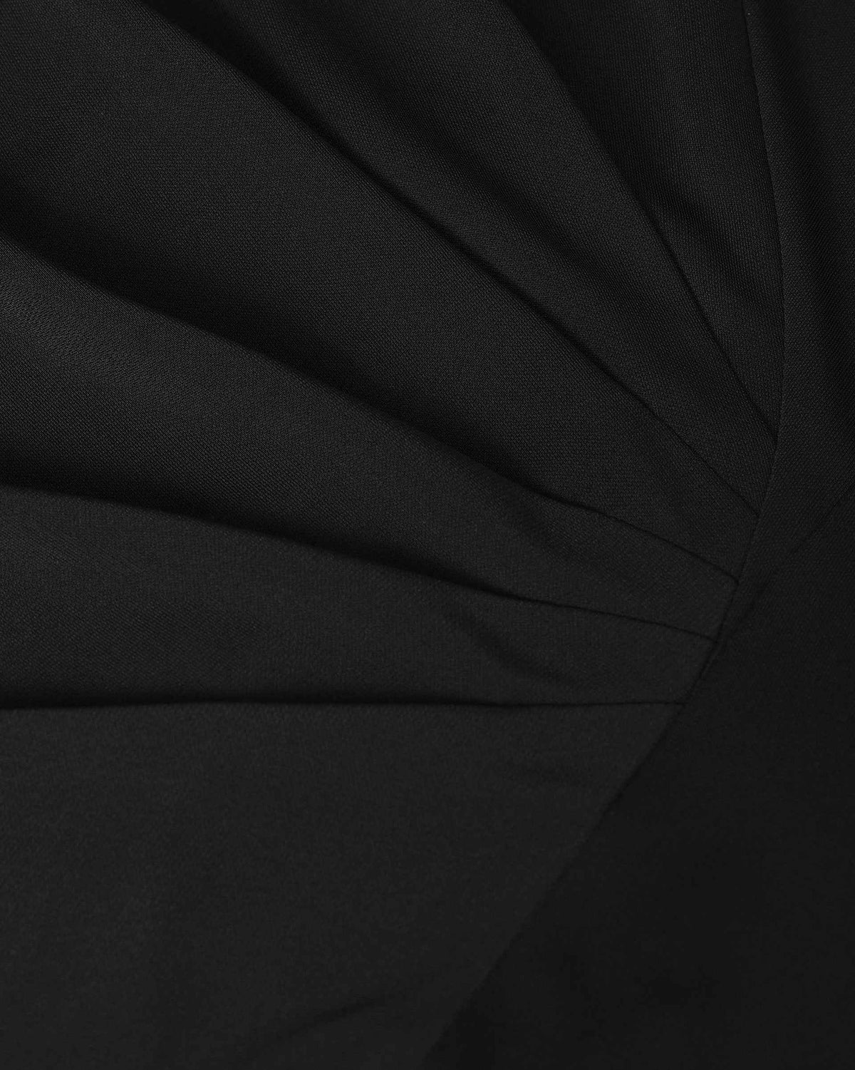 Fine folds gather through the waist, drawing the fabric towards the centre of the blouse.