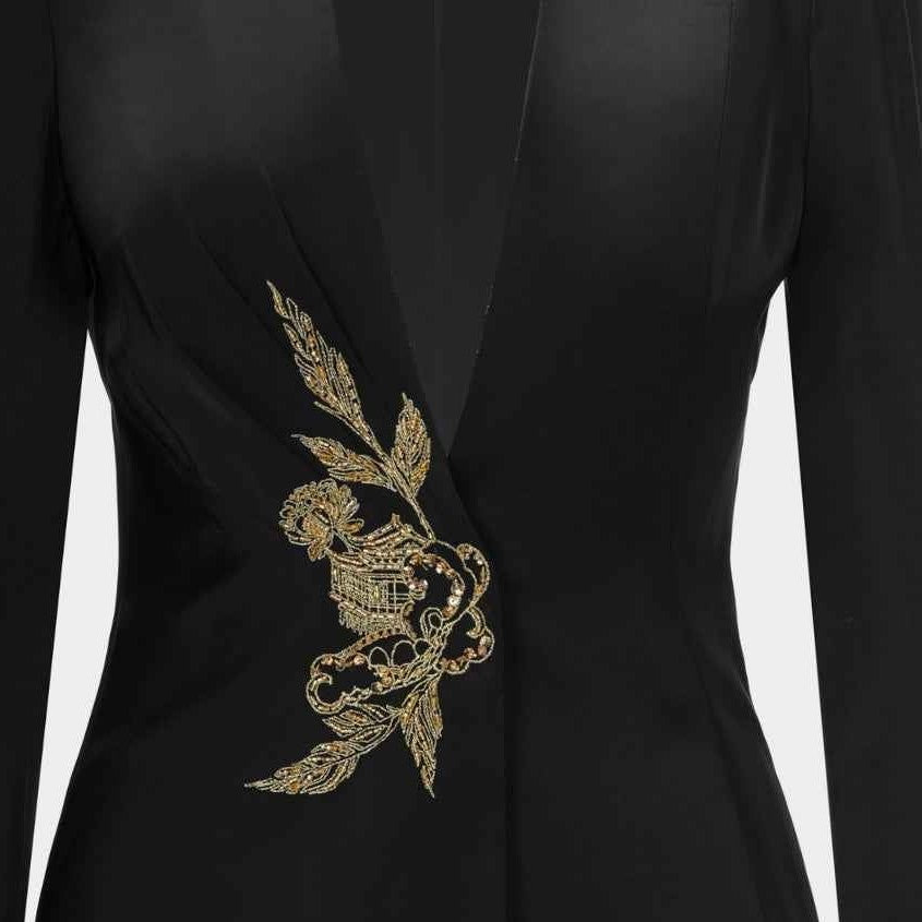 Gold-toned embroidery follows the blazer's front, standing out against the black ground.