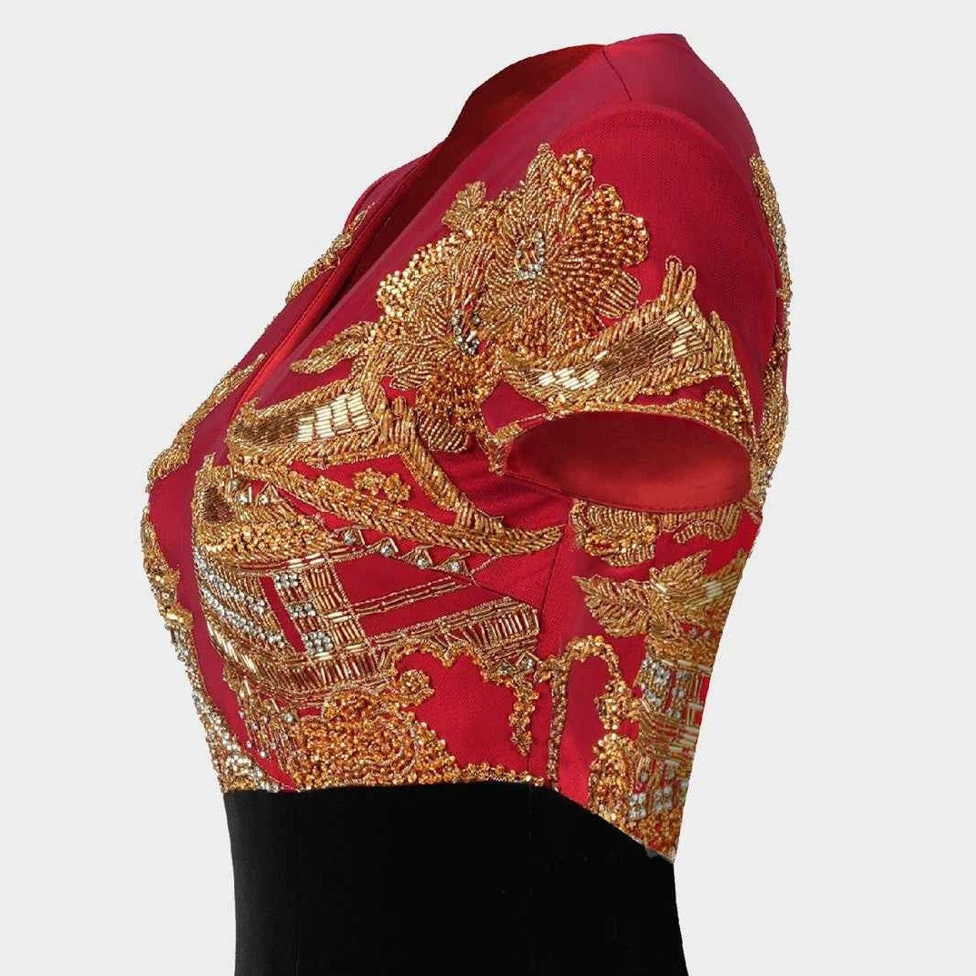 Gold-toned embroidery spreads across the red upper section, standing out against the black skirt below.