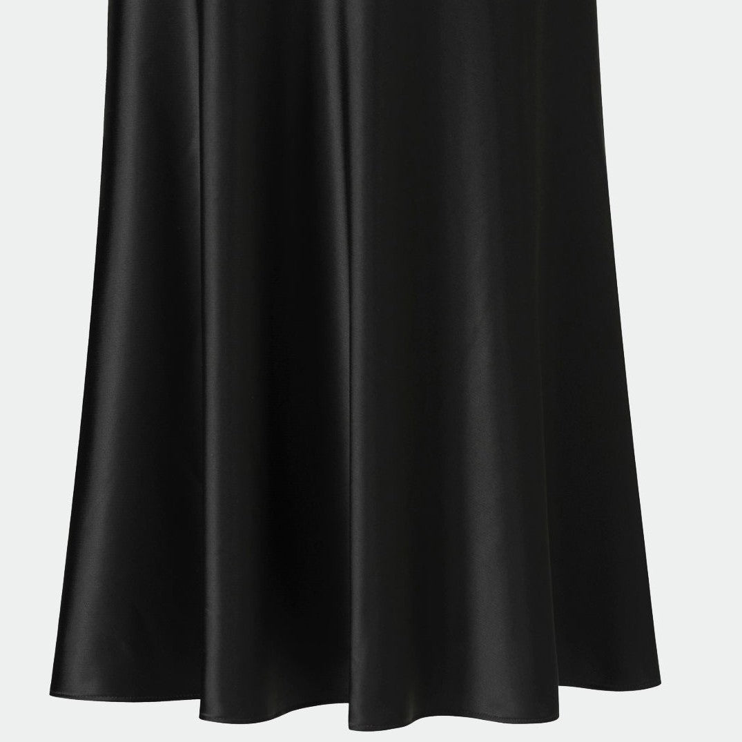 The back view reveals broad folds descending through the skirt, with subtle highlights along their edges.